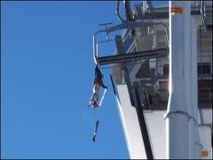 A skier dangles from a chair lift after snagging his backpack